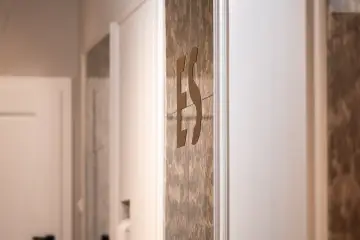 Logo E&S na marmurowej ścianie – detal wnętrza kancelarii